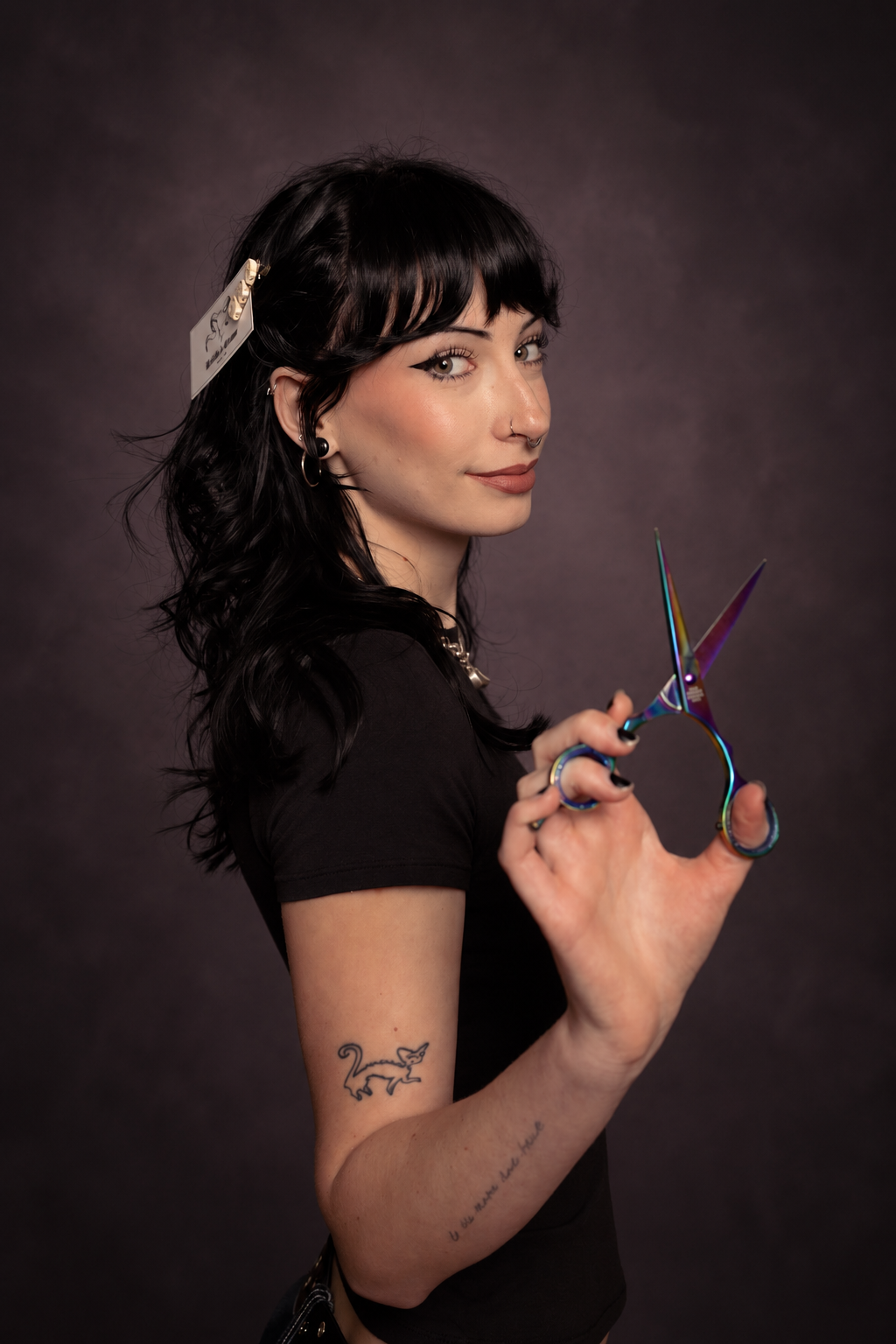 Kaitlin with her iridescent shears against a dark studio backdrop